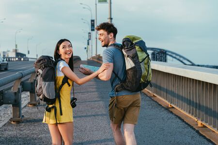 handsome man and asian woman in overalls smiling and looking awayの写真素材