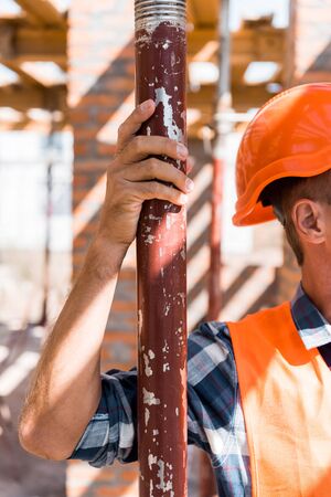 cropped view of mature constructor in orange helmet