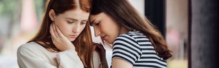 panoramic shot of two sad friends in casual outfitsの写真素材