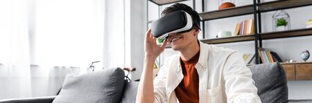 panoramic shot of man with virtual reality headset in apartment