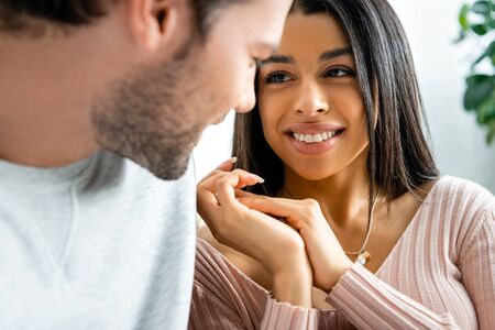 selective focus of smiling african american woman looking at her boyfriend