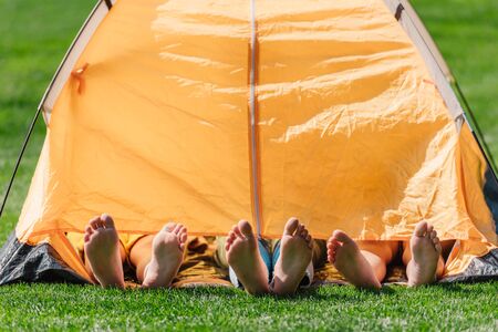 cropped view of kids with barefoot lying in yellow campの写真素材