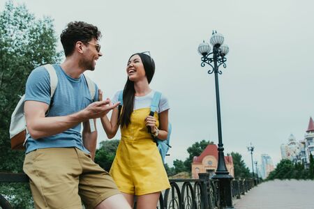 handsome man and asian woman smiling and looking at each other
