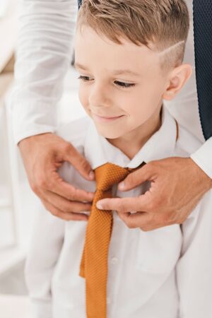 partial view of father and son in white shirts with tiesの写真素材
