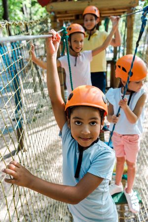 selective focus of african american boy near happy friends in helmets