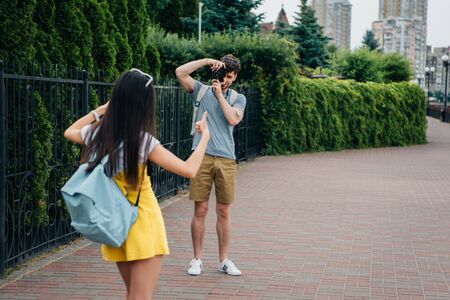 man taking photo and brunette woman showing like gestureの写真素材