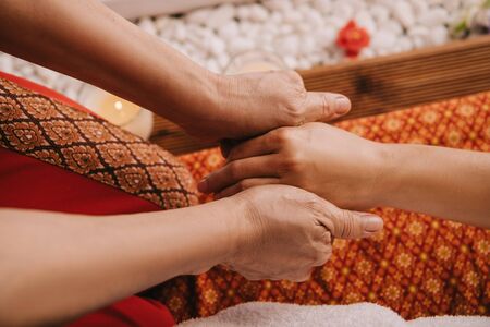 cropped view of masseur doing hand massage to woman in spa salonの写真素材
