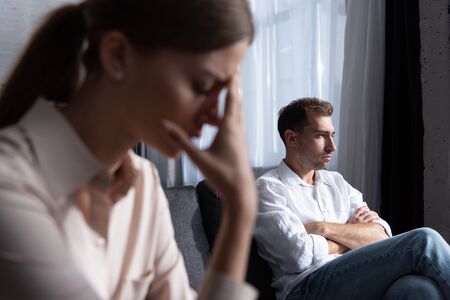 selective focus of sad woman and pensive man on sofaの写真素材