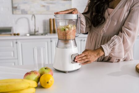 cropped view of pregnant woman preparing smoothie in blenderの写真素材