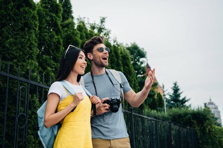 shocked man and asian woman with backpacks looking awayの写真素材