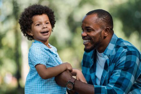 happy african american father holding hands with cute sonの写真素材
