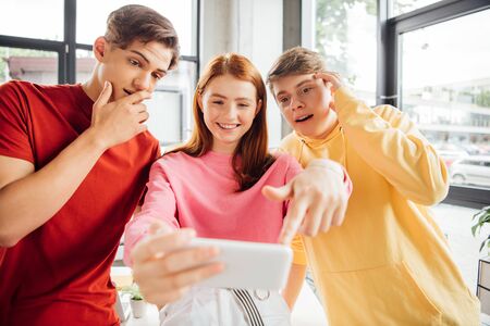 three friends taking selfie and smiling in school