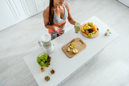 overhead view of girl gesturing while holding glass with smoothieの写真素材