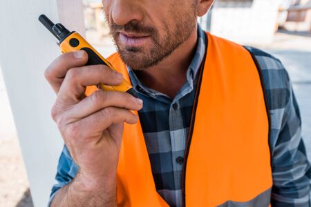 cropped view of bearded man holding walkie talkie
