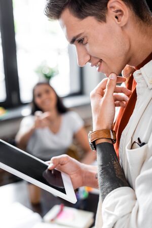 side view of smiling student holding digital tablet with blank screenの写真素材