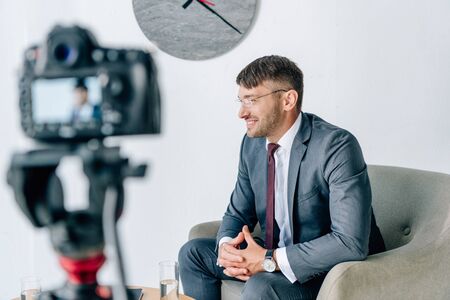 selective focus of businessman in formal wear smiling in office