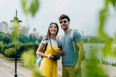 handsome man and asian woman smiling and looking away