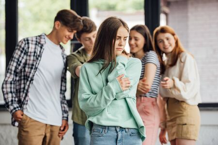 panoramic shot of group of teenagers bullying girlの写真素材
