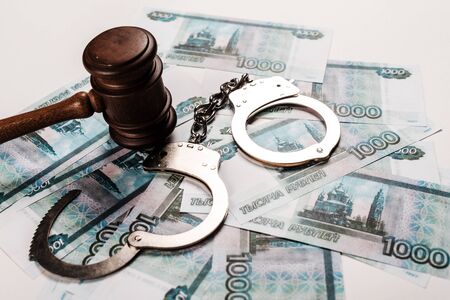 wooden gavel near handcuffs on russian moneyの写真素材