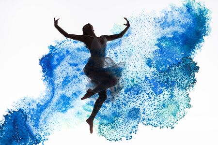 graceful ballerina dancing in blue paint splashes and spills isolated on whiteの写真素材