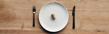panoramic shot of plate with cork and cutlery on wooden surfaceの写真素材