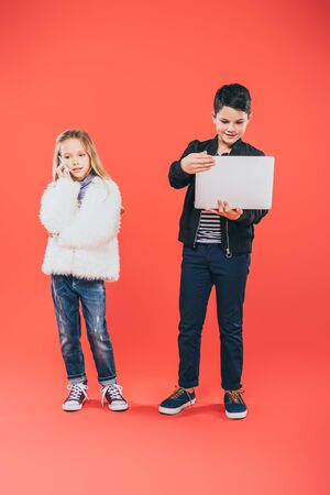 full length view of kids with smartphone and laptop on redの写真素材