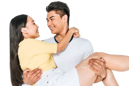 happy asian man holding young girlfriend on hands isolated on whiteの写真素材