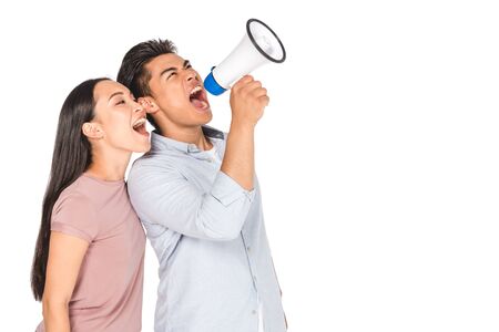 young asian couple screaming into megaphone together isolated on whiteの写真素材