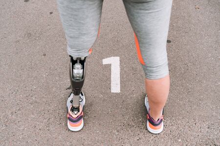 partial view of disabled sportswoman with prosthesis on street