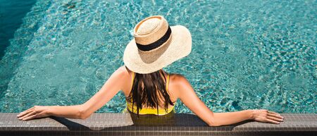 back view on woman in straw hat relaxing in swimming  pool, panoramic shot