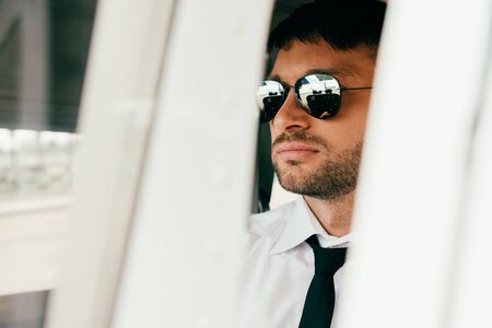 selective focus of confident businessman in formal wear and sunglasses