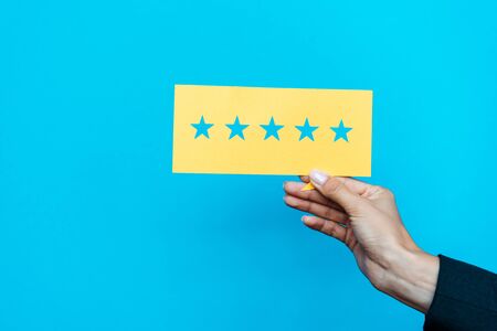woman holding yellow paper with stars isolated on blue 