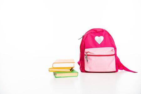 pink backpack with heart symbol and stack of books on white background with copy spaceの写真素材