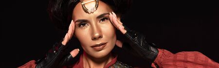 panoramic shot of attractive steampunk woman in leather gloves isolated on black