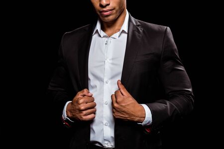 cropped view of bi-racial man touching formal wear isolated on black の写真素材