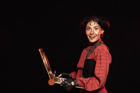 attractive steampunk woman using laptop and smiling isolated on black