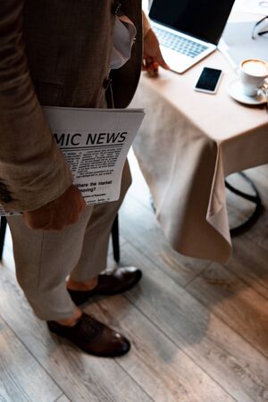 cropped view of businessman holding newspaper in cafeの写真素材