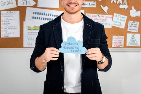 cropped view of businessman in shirt holding paper cloud with external, observation, result lettering の写真素材