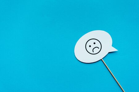 sad face on white speech bubble isolated on blue
