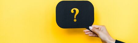 panoramic shot of woman holding black speech bubble with question mark on orange
