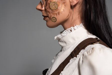 side view of steampunk girl in white blouse with makeup isolated on grey