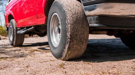 cropped view of red car on ground in sunny day