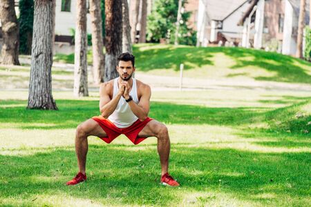 athletic bearded man training on grass in parkの写真素材
