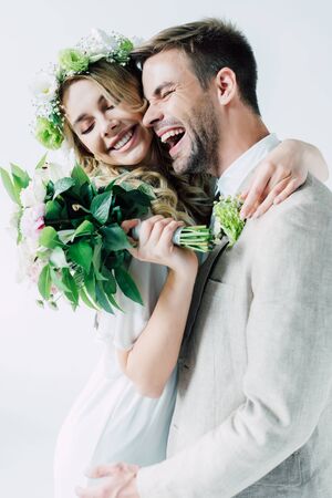 attractive bride and handsome bridegroom hugging with closed eyesの写真素材