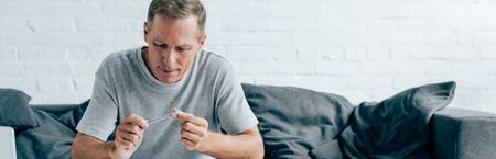 panoramic shot of man holding blunt with medical cannabis