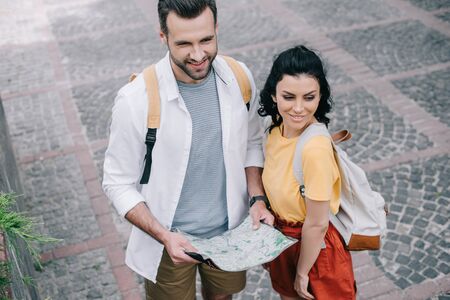 overhead view of happy woman standing near man with map