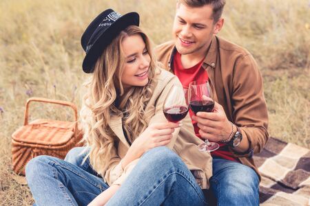 handsome man and attractive woman clinking with wine glassesの写真素材