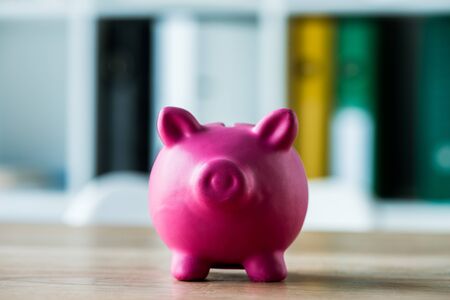toy piggy bank on wooden desk in officeの写真素材
