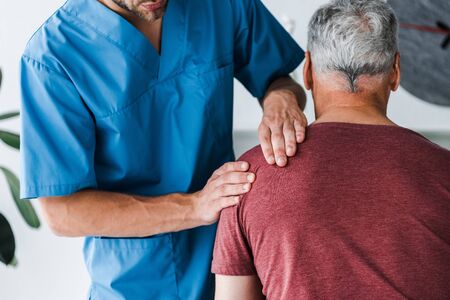 back view of patient sitting near doctor in clinic