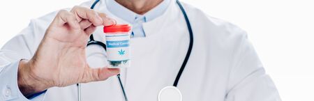 panoramic shot of doctor in white coat holding medical cannabis isolated on whiteの写真素材